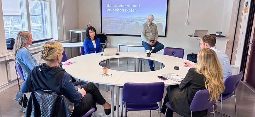 Tre personer ler in i kameran.