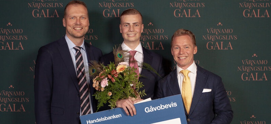 Tre personer ler in i kameran.